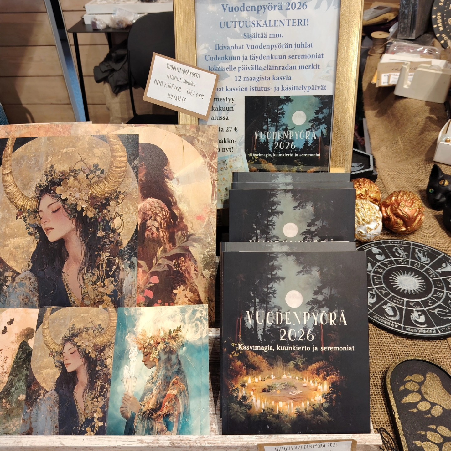 Vuodenpyörä 2026 kalenterikirja ja kauniit kortit ovat kuvituksia kalenterin sisäsivuilta